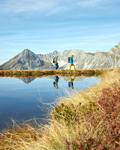Golmer Seenweg im Montafon mit Bergsee, Spiegelung und Wanderern als Ausflugstipp vom Genusshotel Vermala.