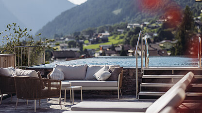 Wellnesslounge im Weitblick SPA des Genusshotel Vermala mit Sky Pool, Sonnenliegen und Bergblick.