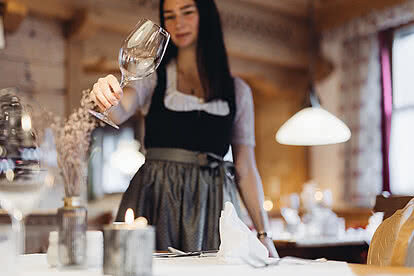 Service employee sets the table in the restaurant of the Hotel Vermala