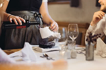 Waitress pours wine in the restaurant of the Hotel Vermala